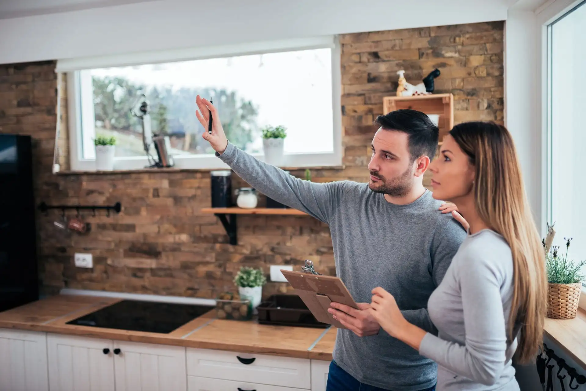 Un couple imagine la nouvelle décoration de sa cuisine, bloc-notes en main