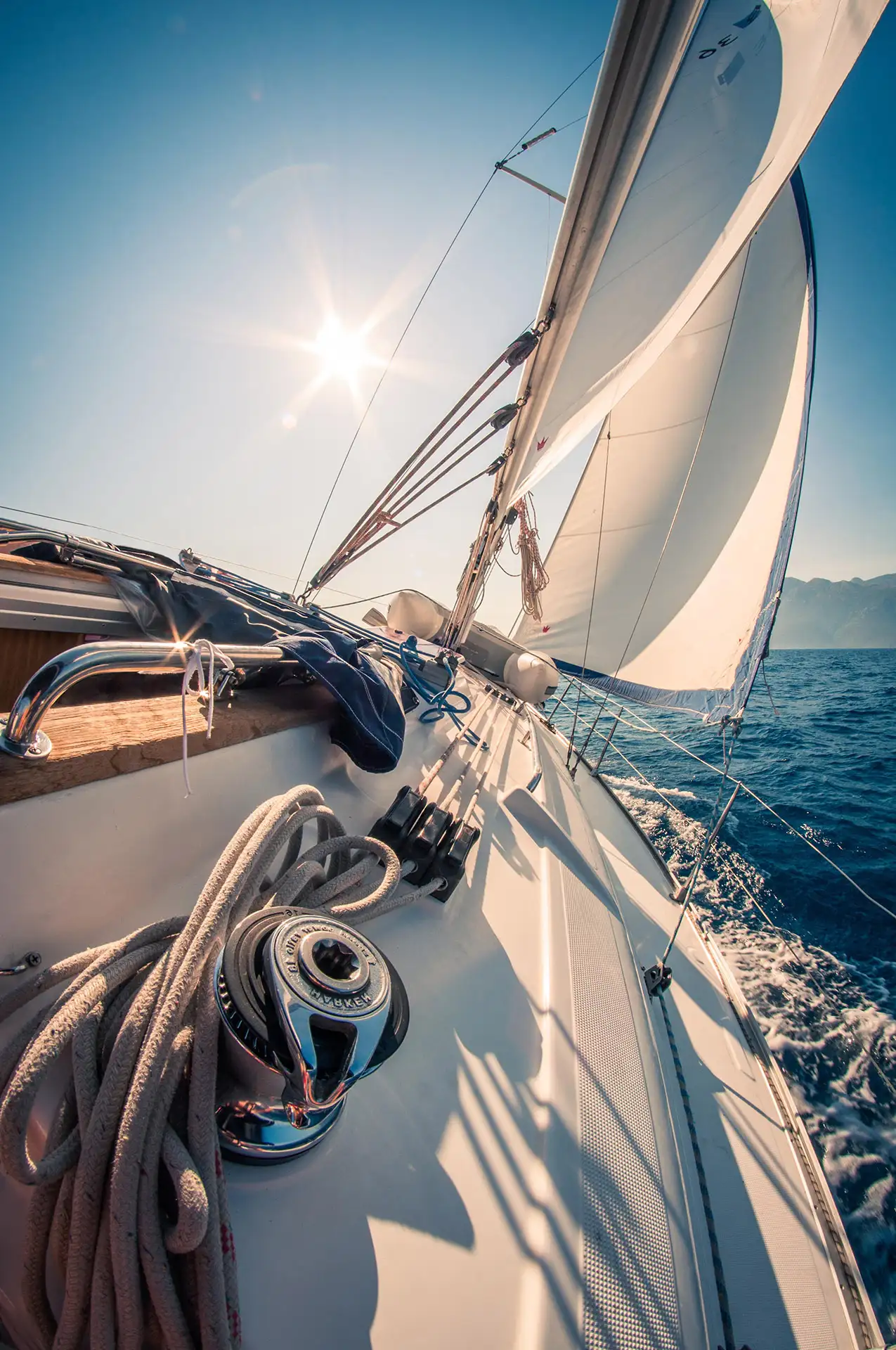 Voilier en pleine mer, voiles gonflées, sous le soleil